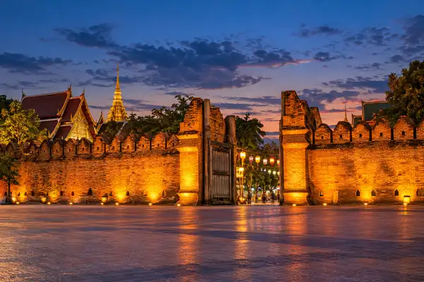 Chiang Mai Old City gate and temple rooflines at dusk before the walking street market