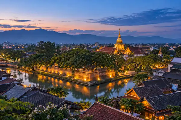 Indy Massage Chiang Mai: Old City rooftop view toward the moat corner and a temple spire at blue hour