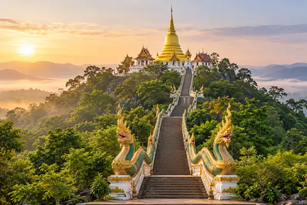 Gold chedi above a long naga staircase climbing through green forest on Doi Suthep
