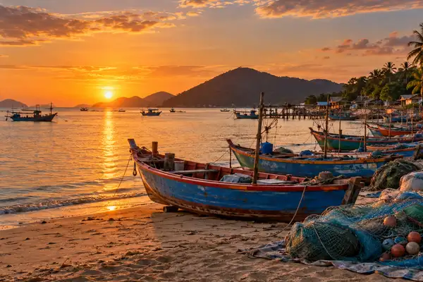 Wooden fishing boats and nets on the shore of Bang Saray fishing village at golden hour