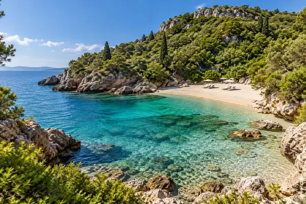 Small sheltered Cosy Beach below a green hill on the Pratumnak side with clear water and rocks