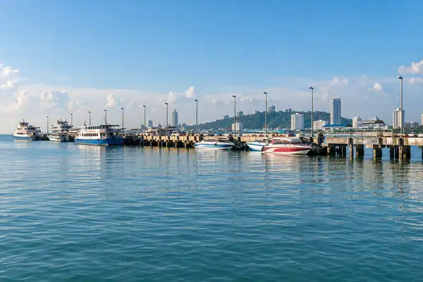 Wooden pier with ferry boats waiting in the morning light at Pattaya