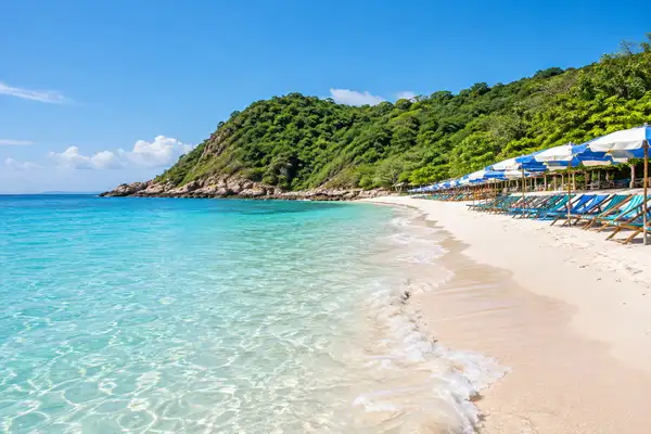 Long Samae Beach on Koh Larn with beach chairs and parasols in clear shallow water