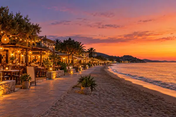 Indy Massage Pattaya: Jomtien beach road at dusk with string lights along open air restaurants and a calm sea