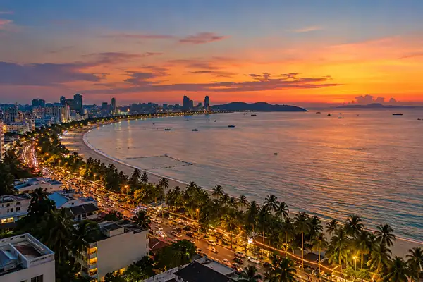 Indy Massage Pattaya: Beach Road skyline and the bay from a high floor at dusk with string lights