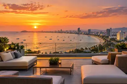 Indy Massage Pattaya: Pattaya rooftop bars guide hero, hotel rooftop terrace at sunset above the curved bay