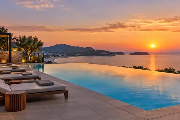 Indy Massage Pattaya: rooftop pool deck at dusk over the bay with empty loungers