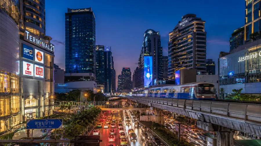 In room massage near Novotel Sukhumvit 4, with shops and the BTS Skytrain on the street at dusk | Indy Massage Bangkok